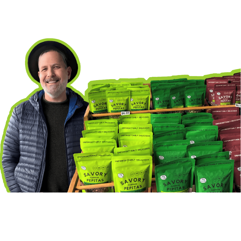 Man standing next to a display of 'Savory' brand food products.